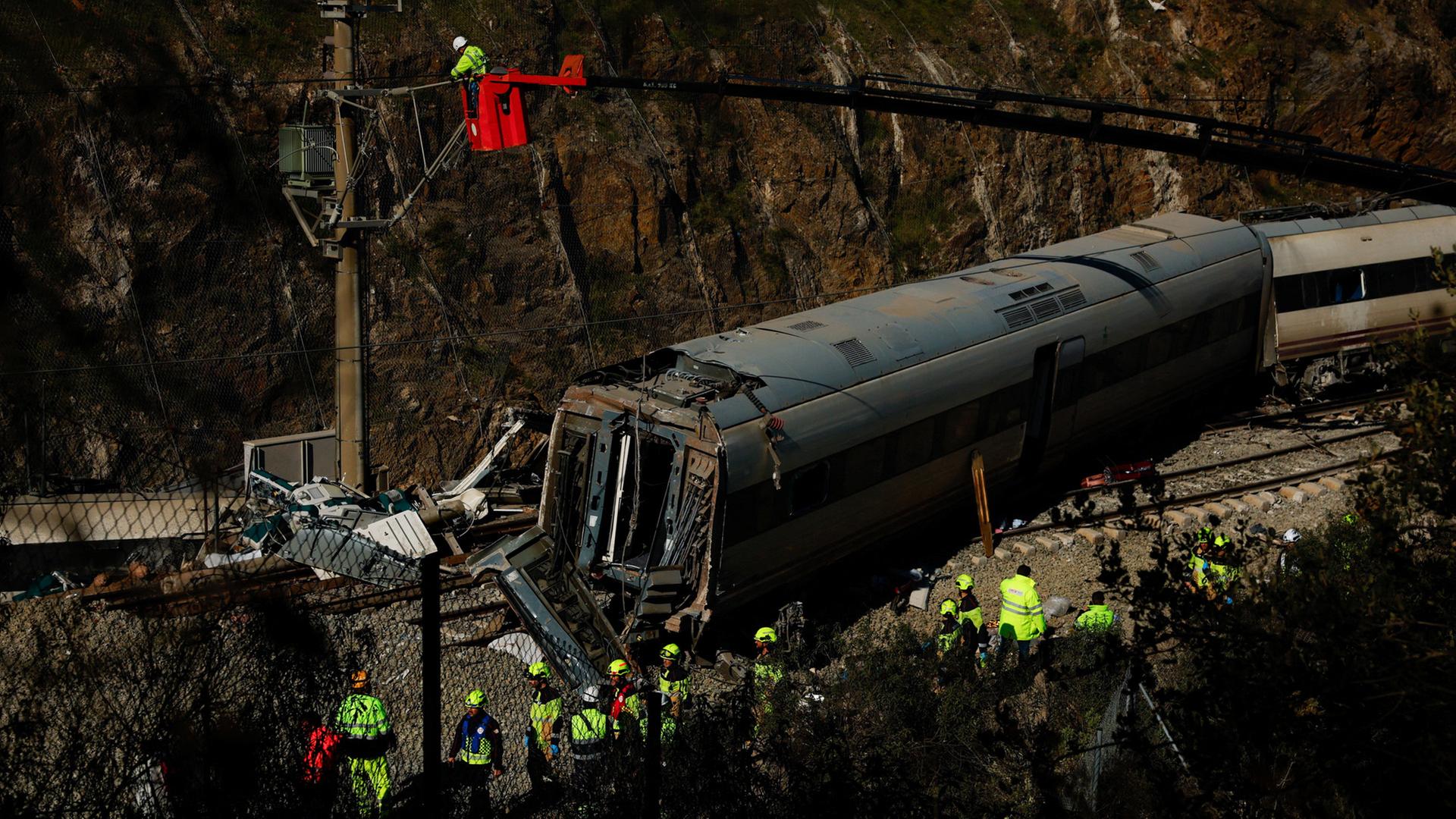 Wartungsarbeiter an den Trümmern eines in den Unfall verwickelten Zuges in der Nähe von Adamuz in Córdoba, Spanien. | REUTERS