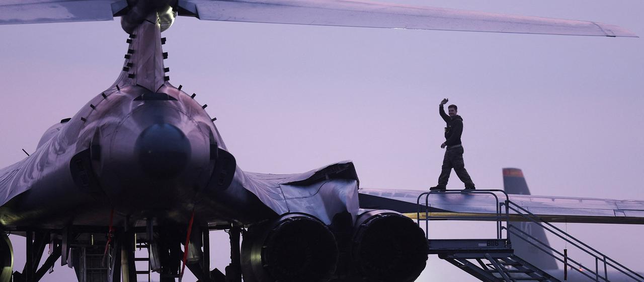 Bodenpersonal bereitet im Morgengrauen ein Militärflugzeug vor.