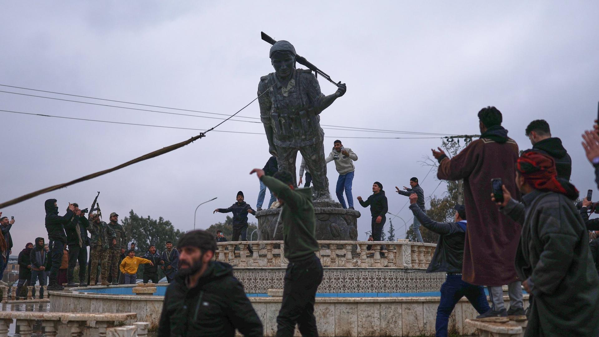 Die Statue einer kurdischen K�mpferin in Rojava wird gest�rzt. | AP