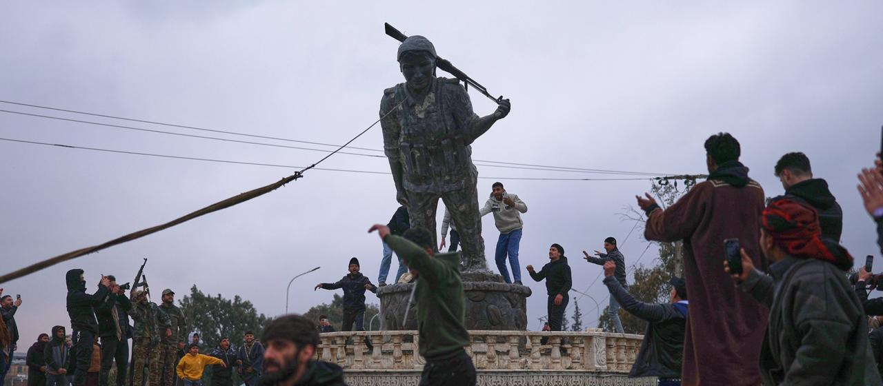Die Statue einer kurdischen Kämpferin in Rojava wird gestürzt.