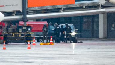 Polizisten führen einen Mann nach der Geiselnahme auf dem Hamburger Flughafen ab