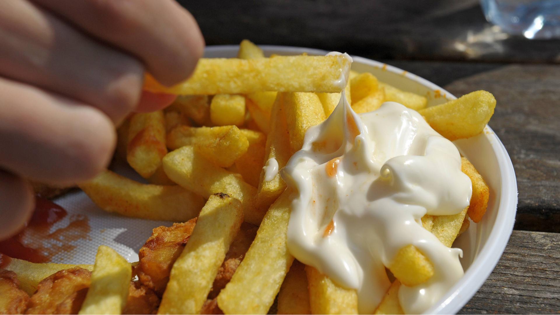 Kind isst Pommes Frites, mit Mayonnaise | imago images/MiS