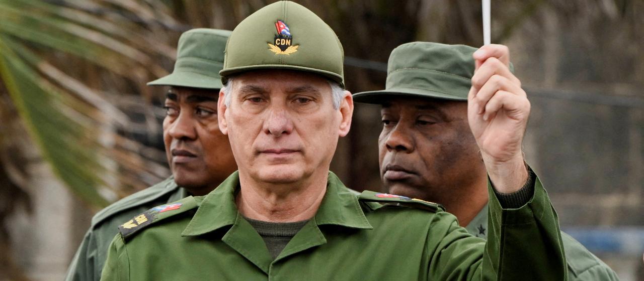 Miguel Díaz-Canel hält eine kubanische Flagge.