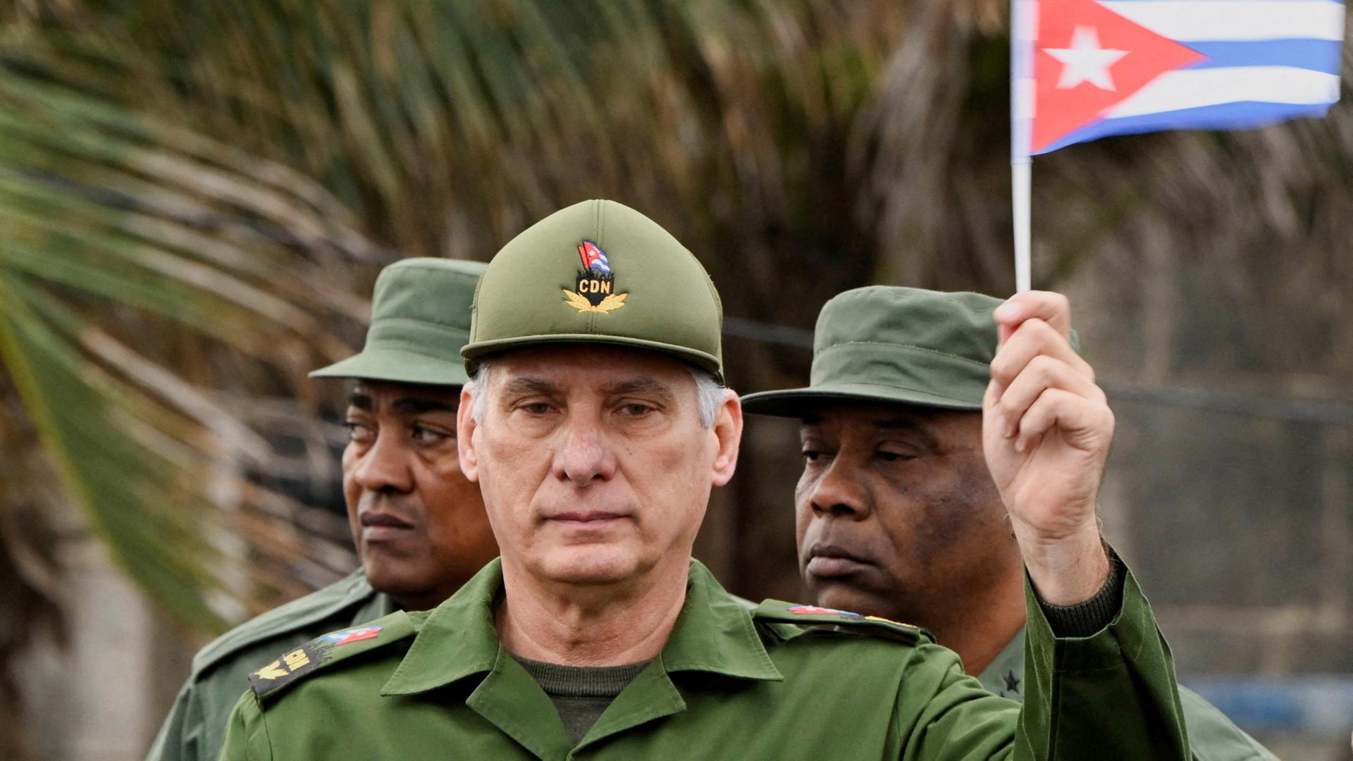 Miguel Díaz-Canel hält eine kubanische Flagge. | REUTERS