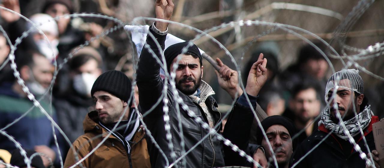 Migranten hinter einem Stacheldrahtzaun am Grenzposten Orestiada