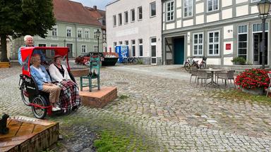 Der Ehrenamtliche Frank Krüger mit den Heimbewohnerinnen Karin Goebels und Ute Heese in einer Rikscha im historischen Stadtzentrum von Angermünde.