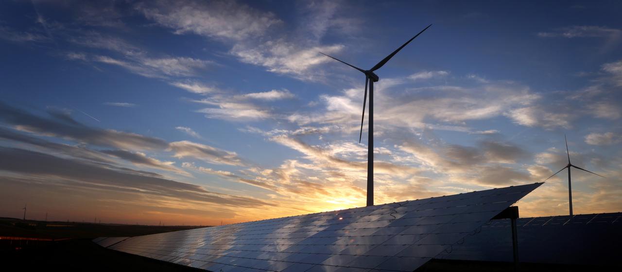 Solar- und Windkraftanlagen in der Dämmerung.