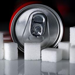 Eine Getränkedose liegt zwischen Zuckerwürfeln.