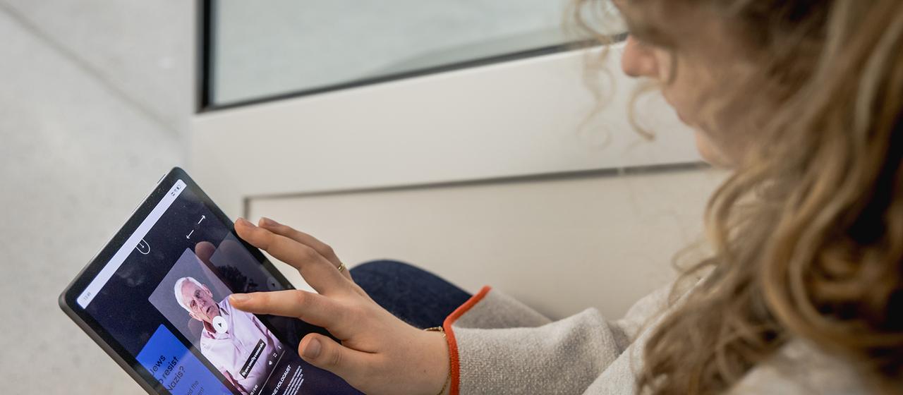 Eine Jugendliche klickt auf das Video eines Zeitzeugen. 