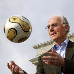 Franz Beckenbauer stellt vor dem Brandenburger Tor den goldenen Fußball für das Finale der WM 2006 vor.