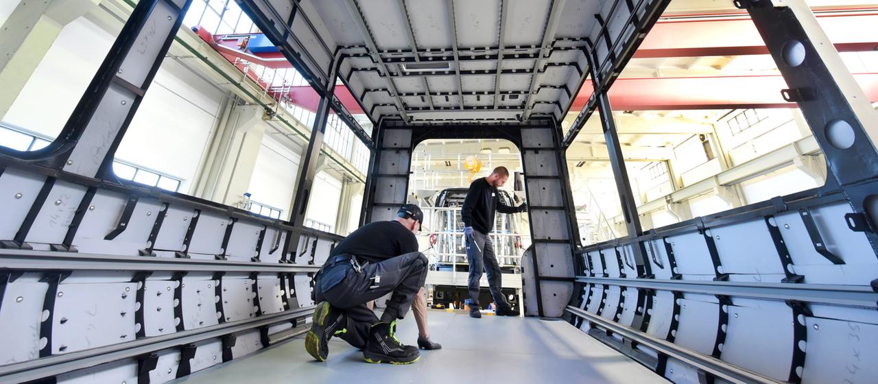 Zwei Industriearbeiter in einer Werkshalle
