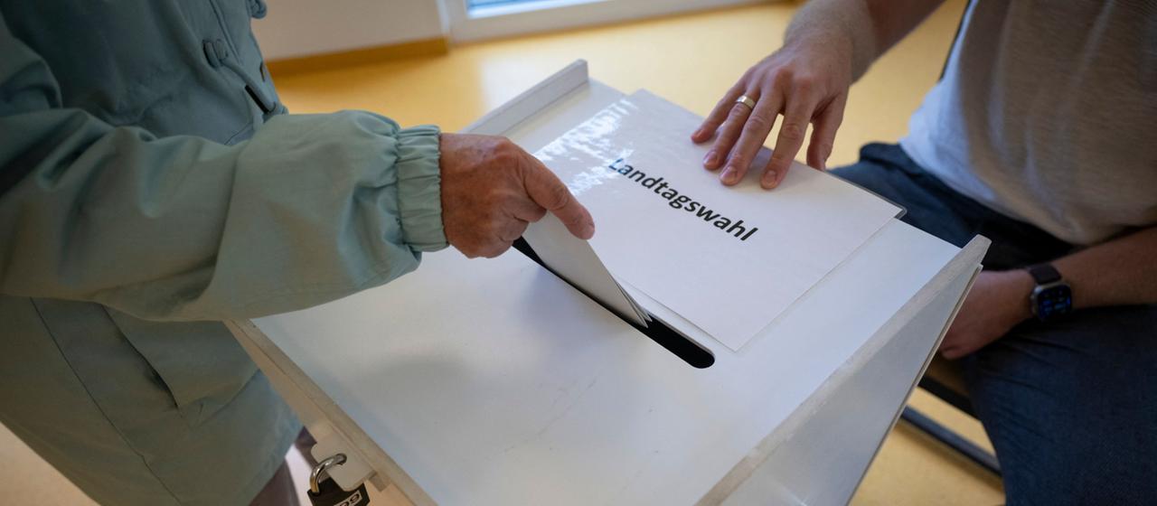Eine Wählerin wirft ihren Stimmzettel in die Wahlurne in einem Wahllokal.