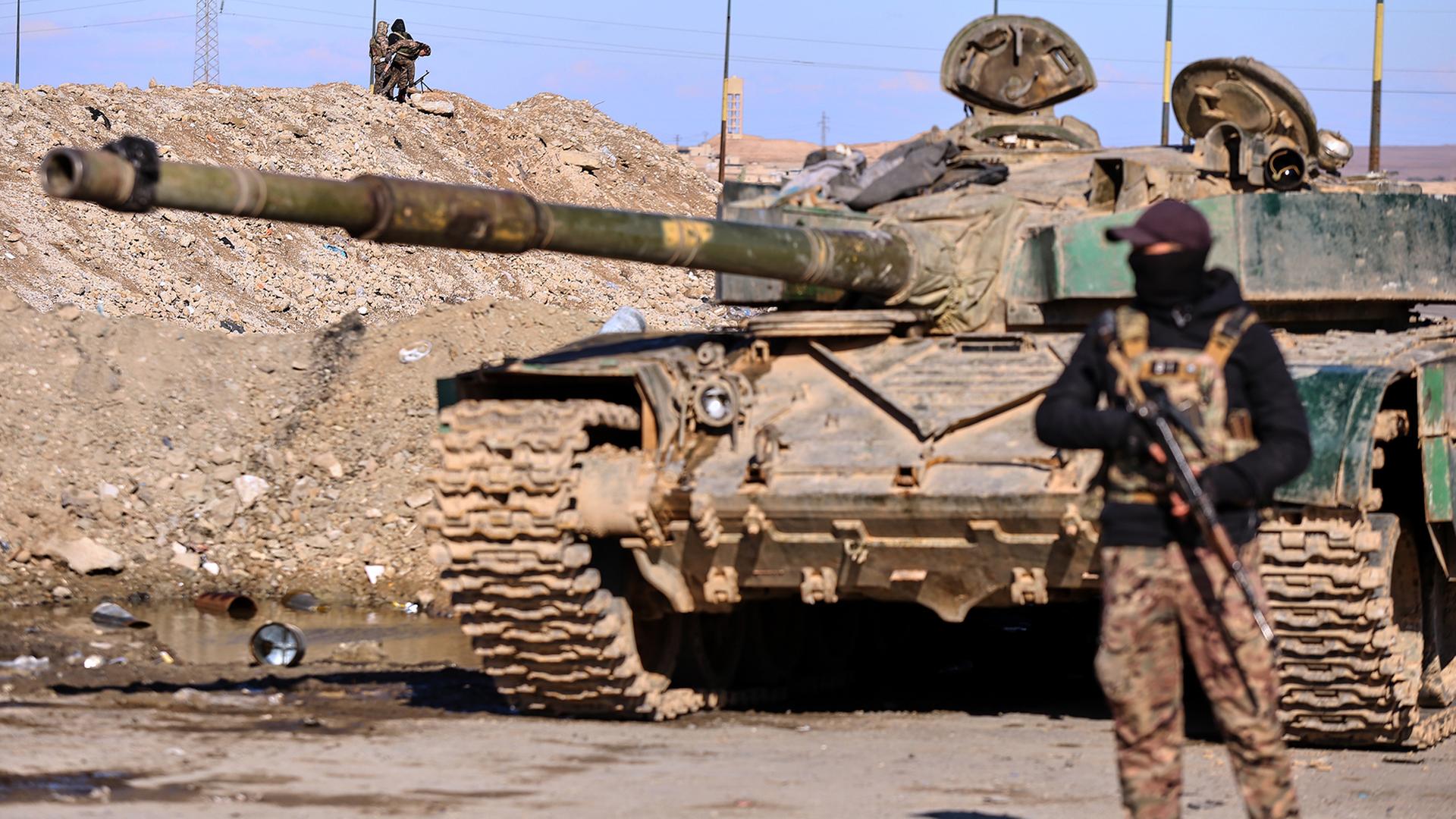 Soldaten der kurdisch geführten Syrischen Demokratischen Kräfte (SDF) sichern mit einem gepanzerten Militärfahrzeug eine Straße in Qamishli (Syrien). | dpa