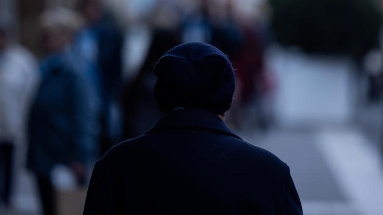 Eine Person geht allein durch die Innenstadt.