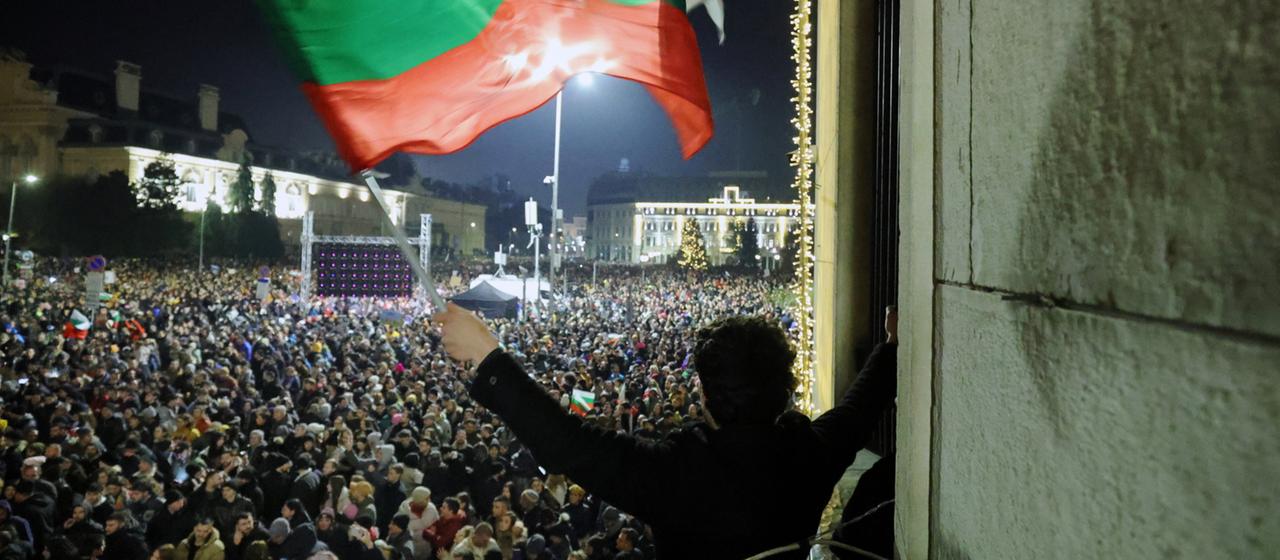 Ein Mann schwenkt bei einer Demonstration eine Flagge von Bulgarien.