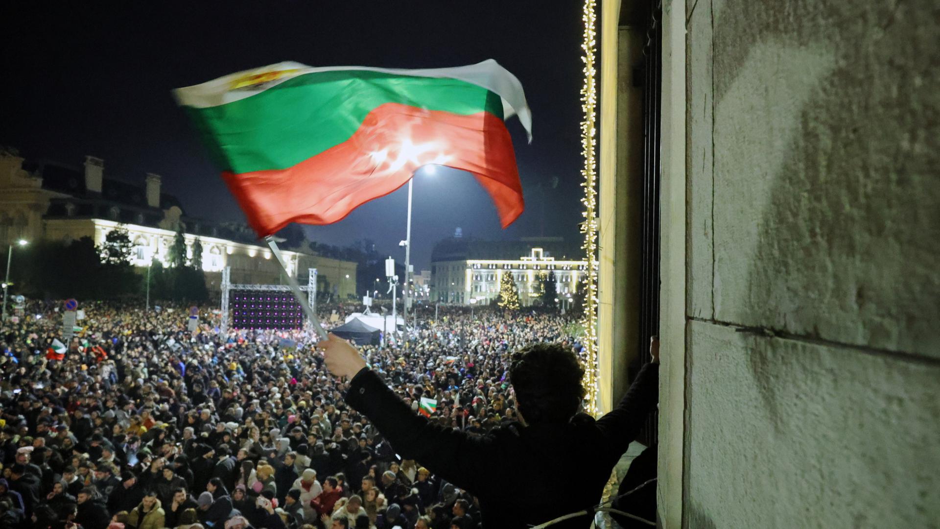Ein Mann schwenkt bei einer Demonstration eine Flagge von Bulgarien. | AP
