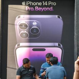 Männer vor einem iPhone-14-Werbeplakat in Neu Delhi, Indien