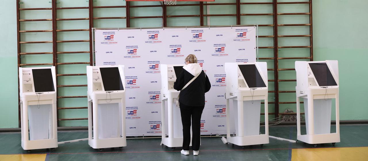 Eine Frau steht an einem Wahl-Automaten in Russland