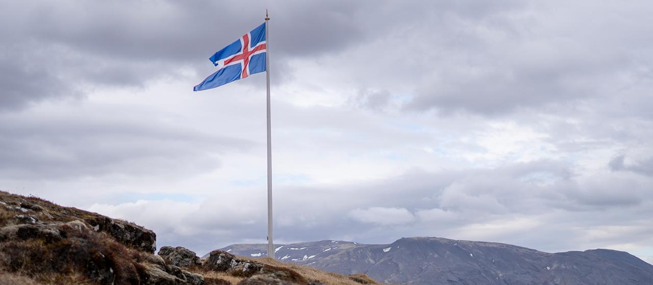 Isländische Flagge im Wind im späten Frühling im Thingvellir-Nationalpark, Island.