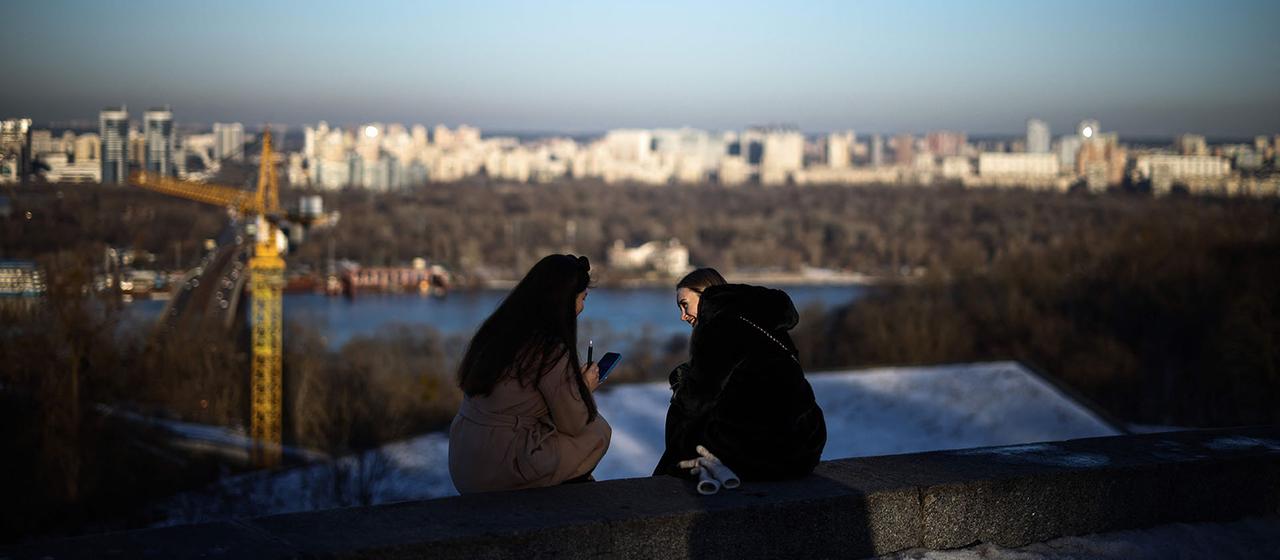 Die Menschen entspannen sich in der späten Nachmittagssonne im Park der Ewigen Ehre in Kiew, Ukraine.
