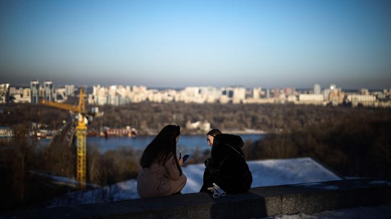 Die Menschen entspannen sich in der späten Nachmittagssonne im Park der Ewigen Ehre in Kiew, Ukraine.