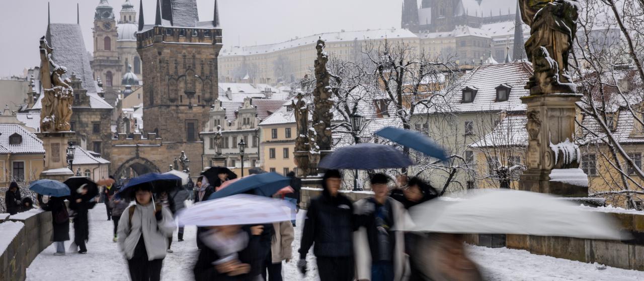Passanten gehen über die Karlsbrücke in Prag