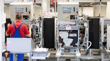 Ein Mitarbeiter führt die Endkontrolle eines Geschirrspülers an einem Band in der Produktion der Miele & Cie. KG durch.