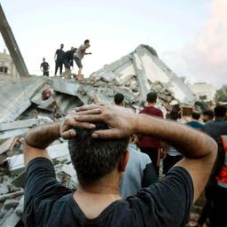 Ein Mann beobachtet einen Rettungseinsatz in einem zerstörten Haus im Gazastreifen
