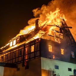 Ein großes Bauernhaus steht in Flammen.