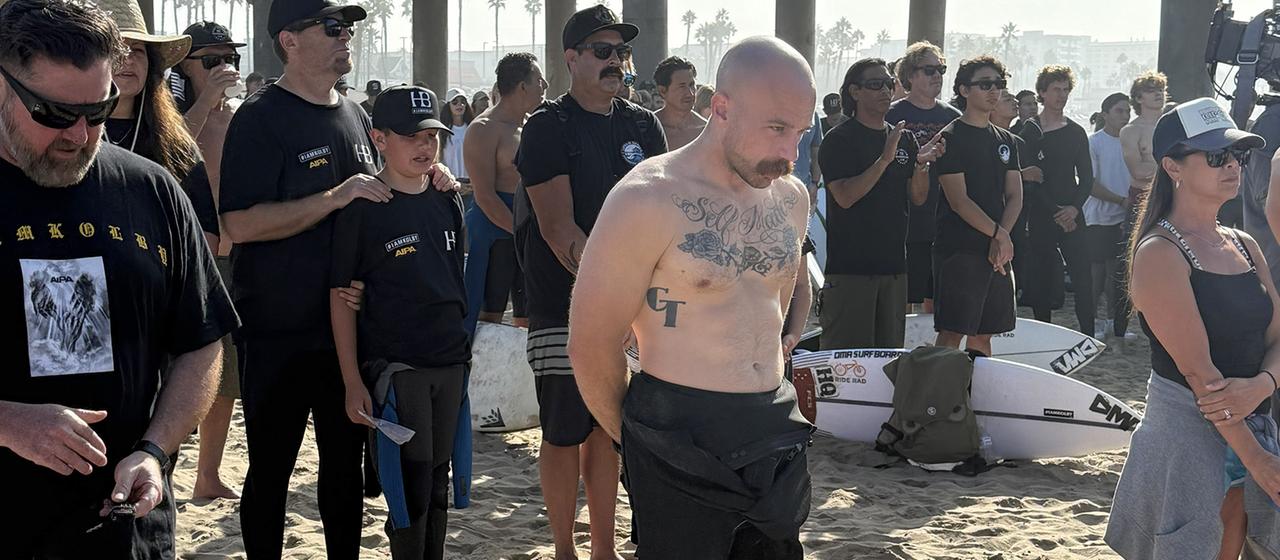 Charlie Rutkowski steht inmitten einer Menschenmenge am Huntington Beach, USA