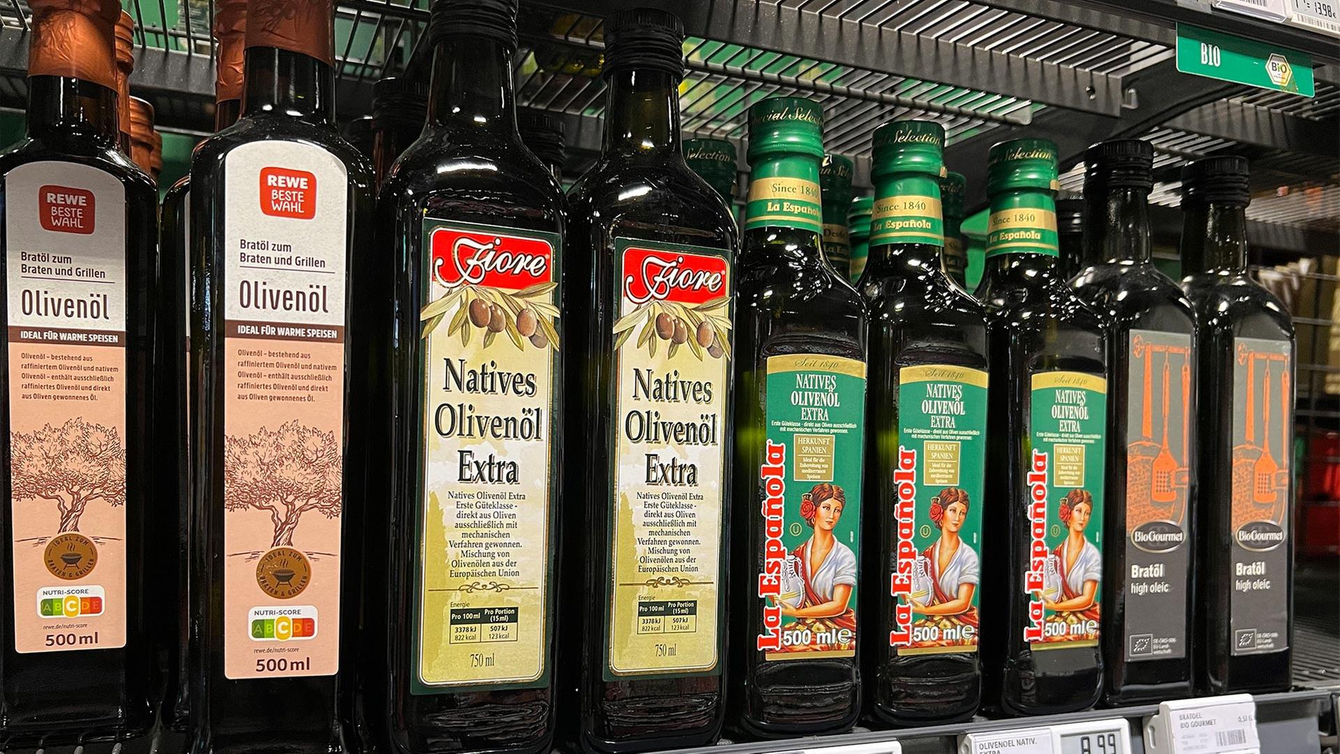 Olivenöl verschiedener Marken in einem Supermarktregal. | picture alliance / SVEN SIMON