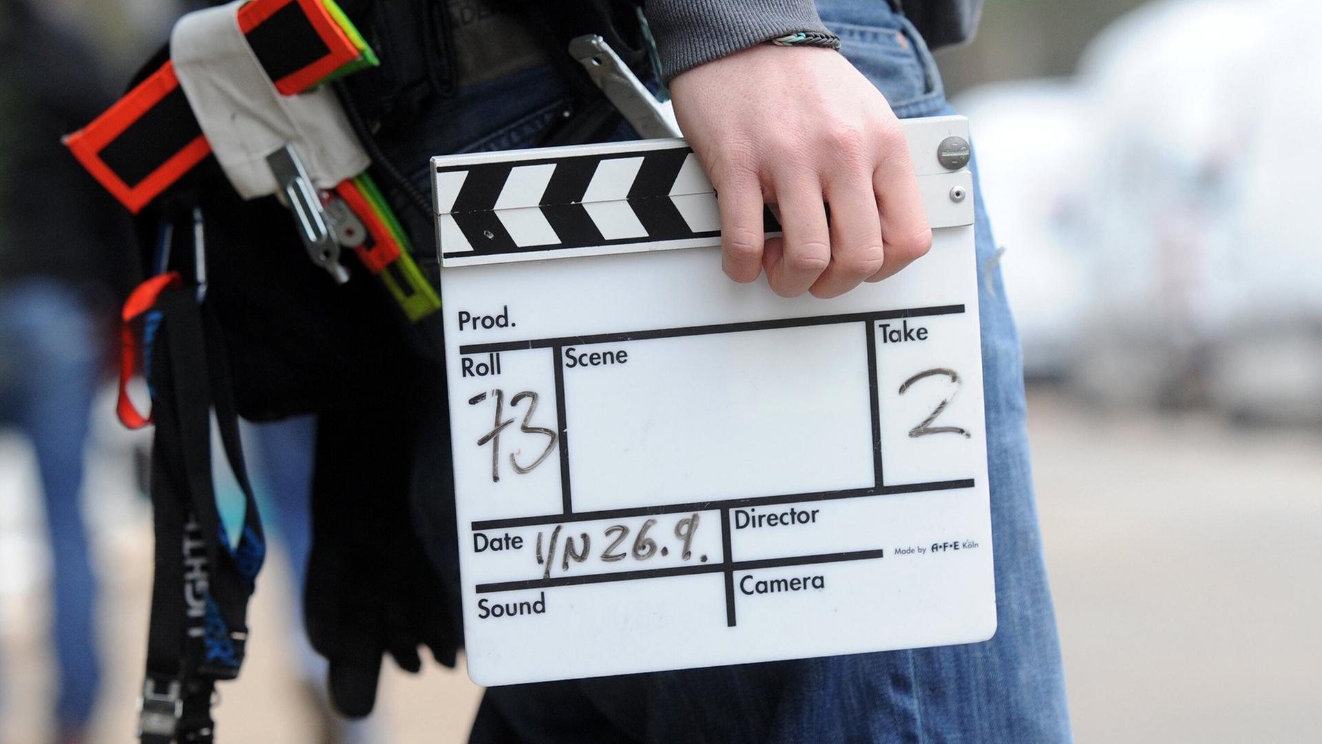 Ein Mitarbeiter eines Filmteams hält eine Filmklappe.  | picture alliance/dpa