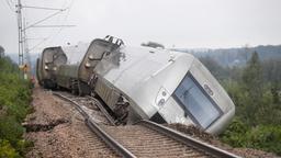 Ein entgleister Personenzug liegt neben den Schienen.