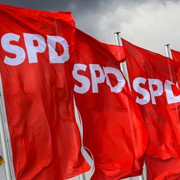 SPD-Fahnen wehen vor dunklen Wolken