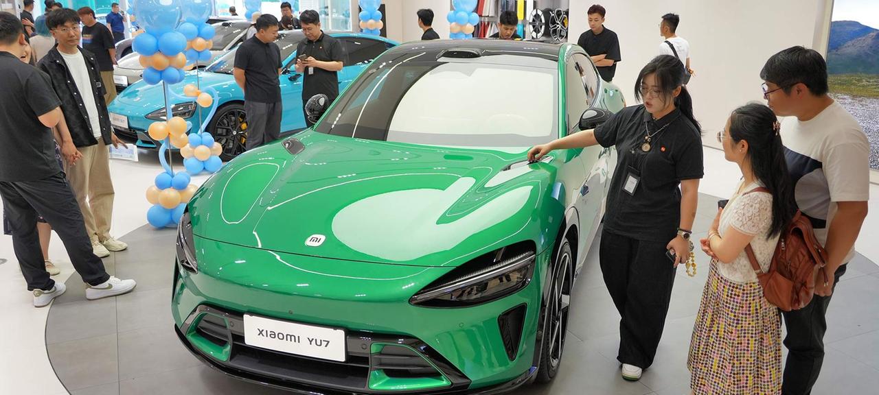 Kunden lassen sich das E-Auto Xiaomi YU7 erklären, bei einer Niederlassung in Yantai, China.