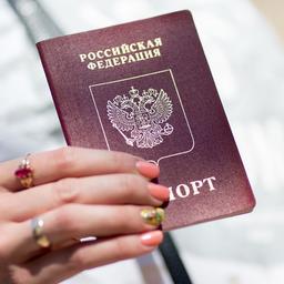 Eine Frau hält einen russischen Pass.