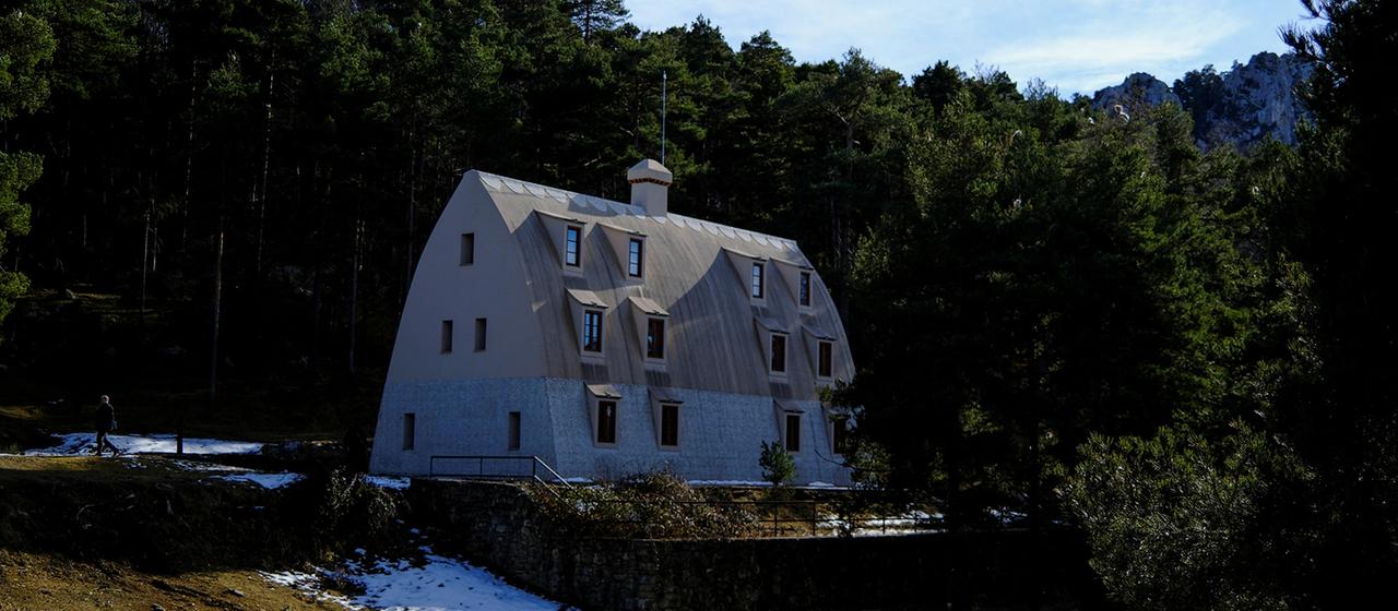 Ein Besucher spaziert um die Berghütte Xalet del Catllaras in den Pyrenäen herum.