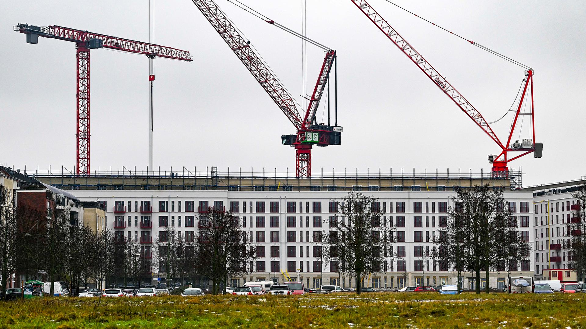 Mehrere Baukräne stehen über einem im Bau befindlichen Wohngebäude in Berlin | dpa