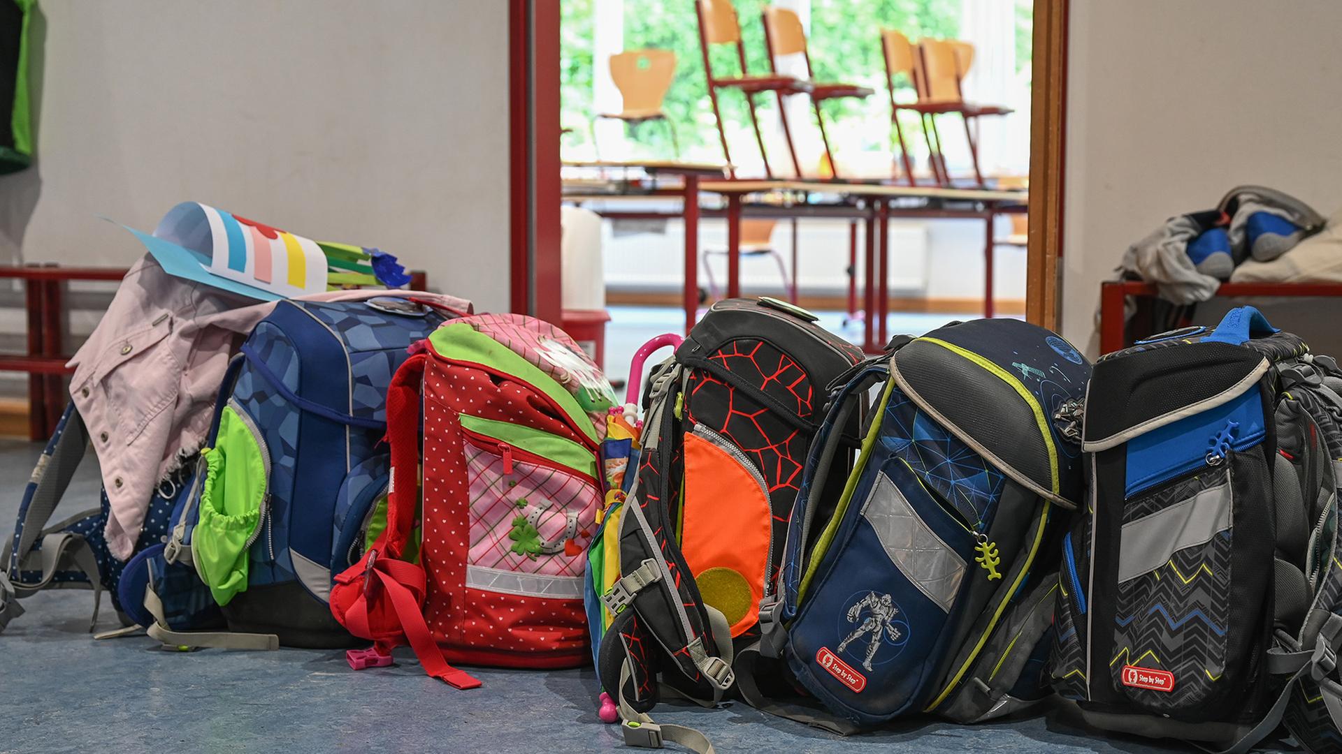 Schulranzen stehen vor einem Klassenzimmer. | dpa