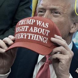 Donald Trump hält eine Kappe mit der Aufschrift 