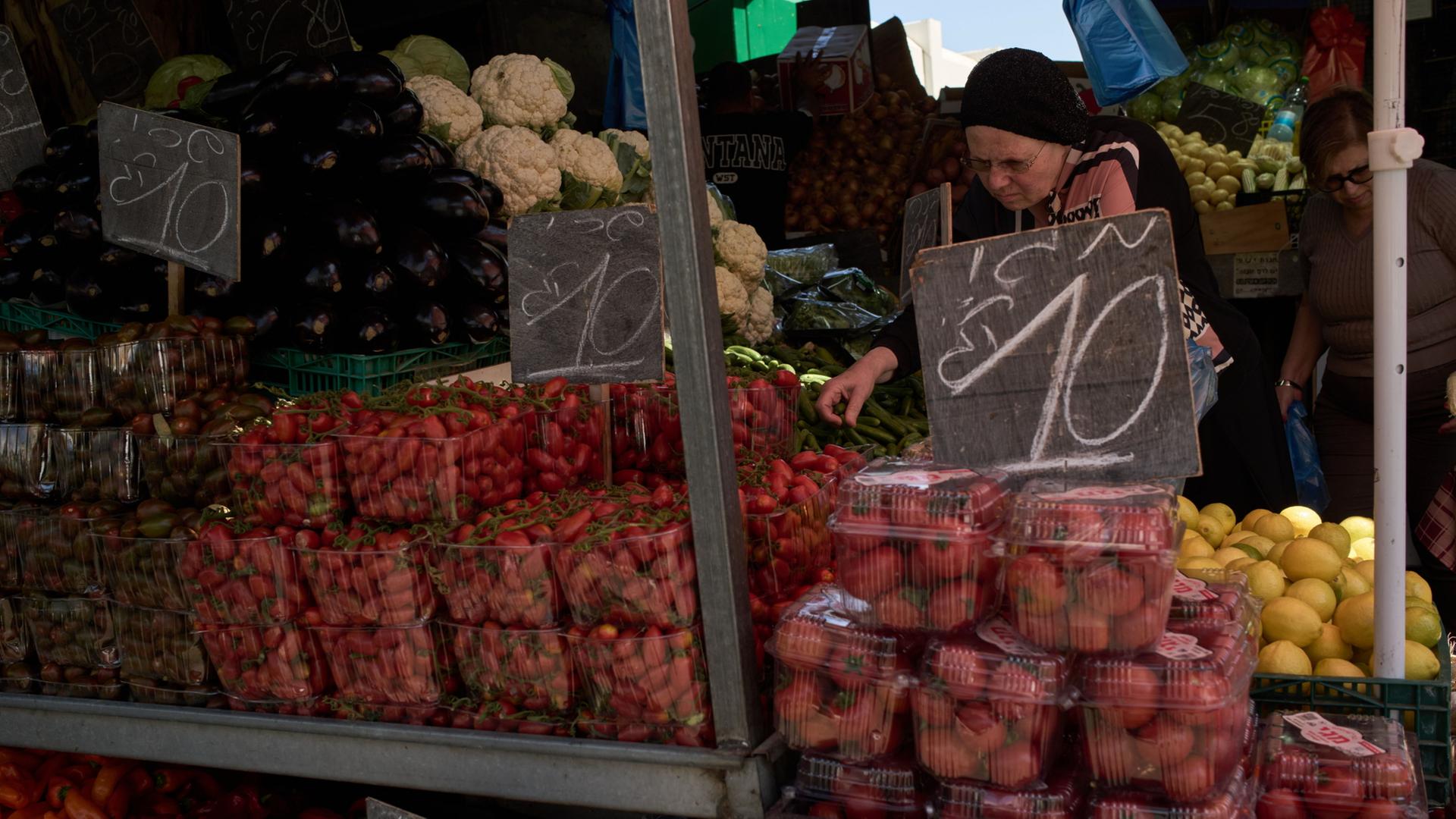 Eine Frau an einem Marktstand in Haifa in Israel | AP Photo/Leo Correa