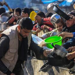 Palästinenser versammeln sich mit Töpfen, um an einer von einer Wohltätigkeitsorganisation eingerichteten Spendenstelle Lebensmittel entgegenzunehmen