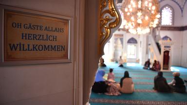 Gläubige sitzen in einer Moschee.