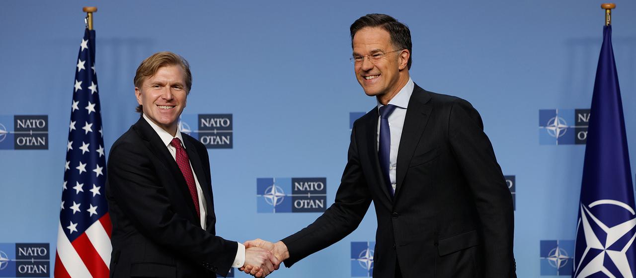 Elbridge Colby und Mark Rutte schütteln sich die Hände.