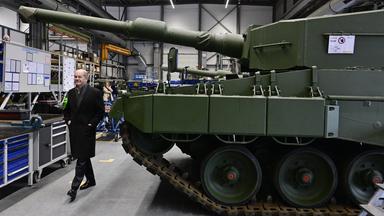 Olaf Scholz geht an einem Panzer am Rheinmetall-Standort Unterlüß/Niedersachsen vorbei.