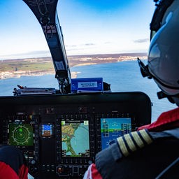 Ein Pilot fliegt einen Hubschrauber über der Ostsee Richtung Sassnitz.