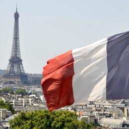 Die Flagge Frankreichs weht vor dem Eiffelturm in Paris.