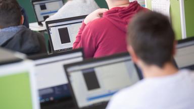 Schüler sitzen im Unterricht vor Bildschirmen.