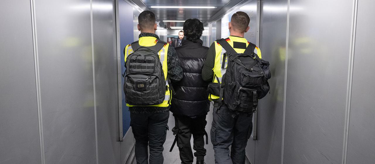Beamte der Bundespolizei bringen einen Mann auf einen Abschiebeflug. | dpa Beamte der Bundespolizei bringen einen Mann auf einen Abschiebeflug.