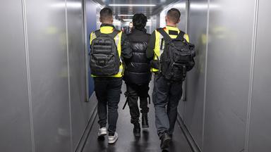 Beamte der Bundespolizei bringen einen Mann auf einen Abschiebeflug.